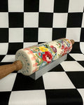 Decorative rolling pin with floral design on a black and white checkered background