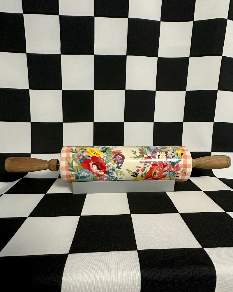 Floral-patterned rolling pin on a black and white checkered background