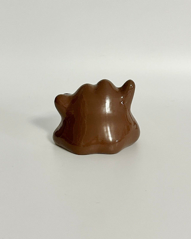 Small brown dog figurine on a white surface