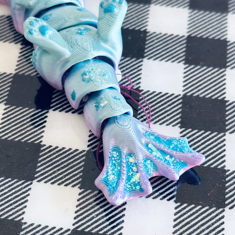 Meet TidalTwinkle the MerCat! A 3D-printed, hand-painted fidget collectible with silky teal and purple hues. Magical, calming, and perfect for ocean lovers! 