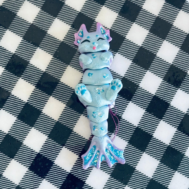 Meet TidalTwinkle the MerCat! A 3D-printed, hand-painted fidget collectible with silky teal and purple hues. Magical, calming, and perfect for ocean lovers! 