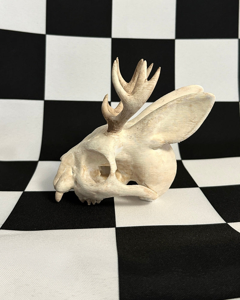 jackalope skull figurine on a black and white checkered background