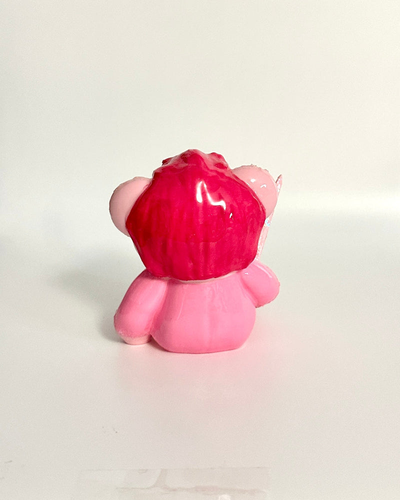 Pink and red toy with a textured surface on a white background