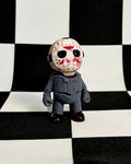 Figurine with a mask on a black and white checkered background