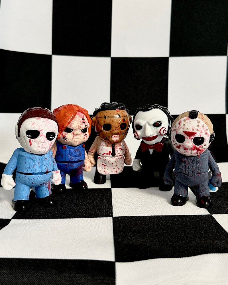 Five toy figures with different faces on a black and white checkered background