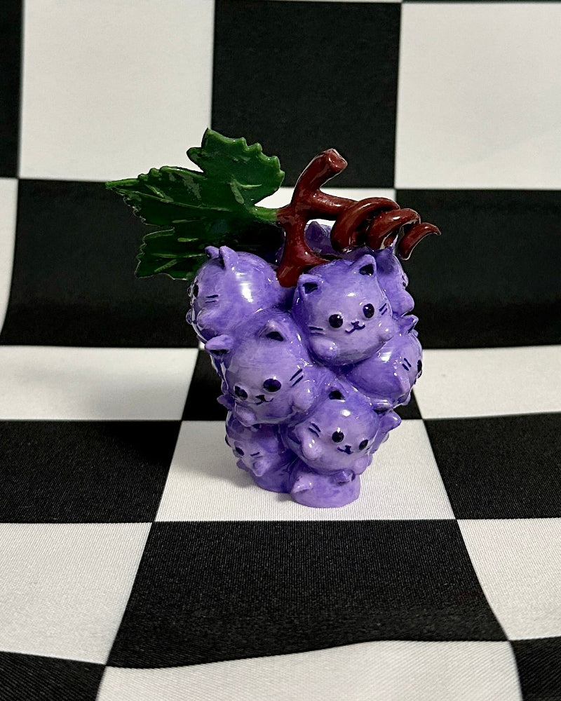 Purple decorative item shaped like grapes on a black and white checkered background