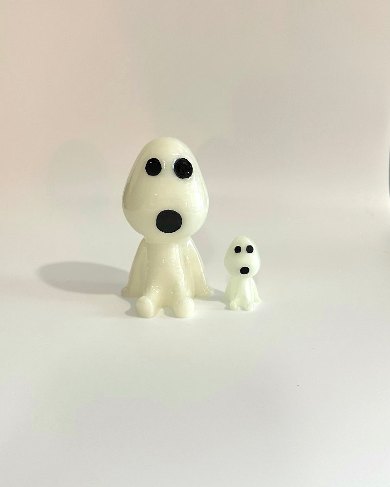 Two small white ghost figurines on a plain background
