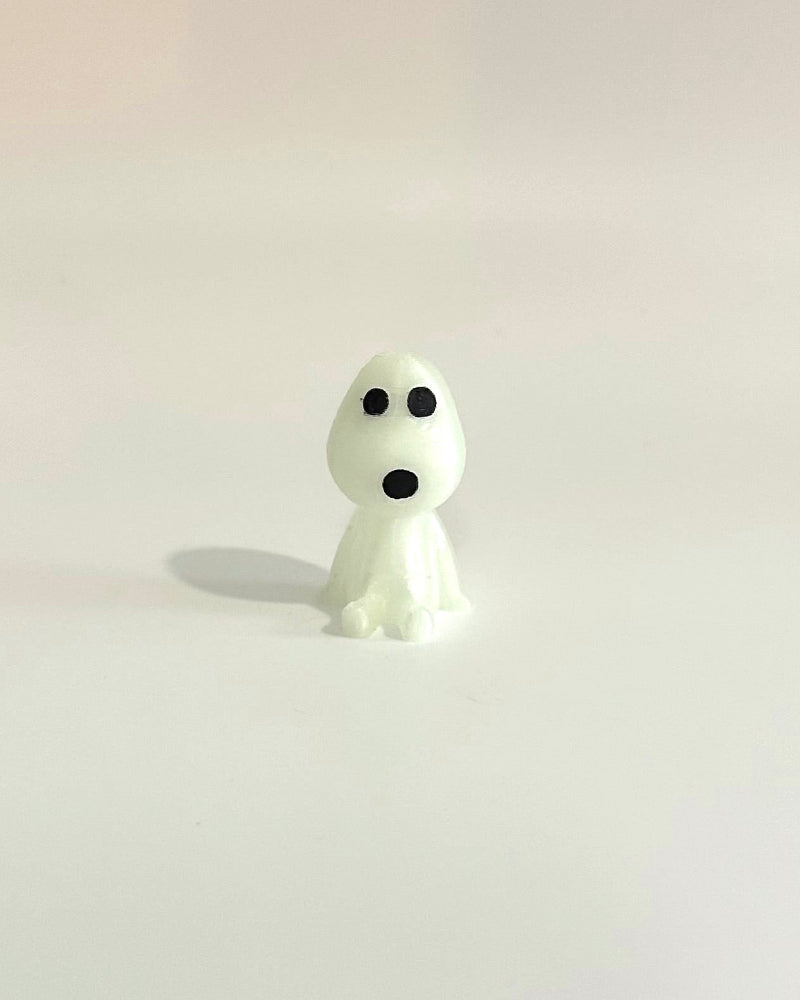 Small white ghost figurine on a light white background