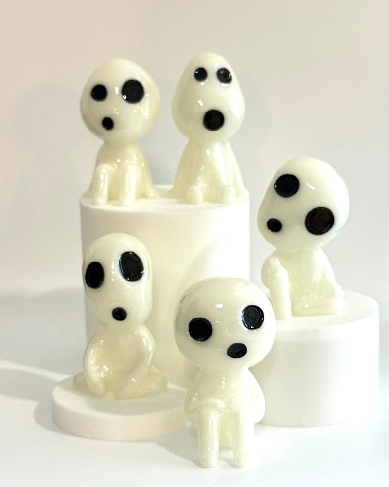 White ceramic family figurine with black details on a white surface.