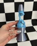 Hand holding a blue and silver novelty item against a checkered background