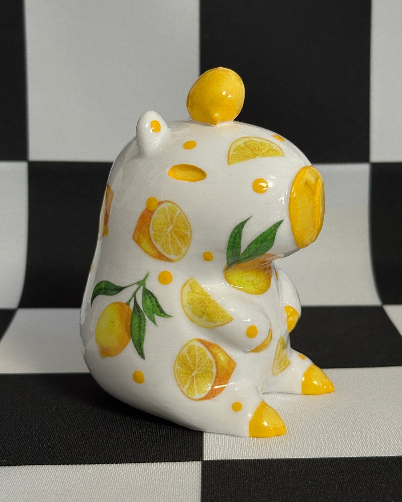 capybara figurine with lemon design on a black and white checkered background