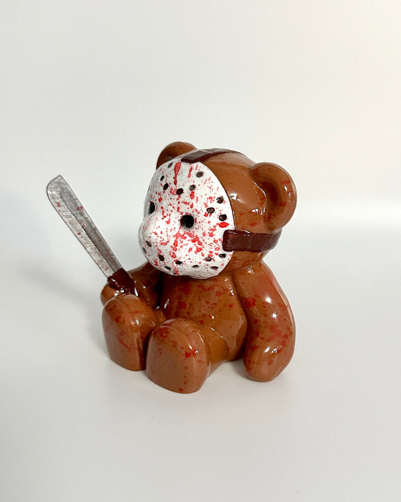 Teddy bear with a hockey mask and knife on a white background