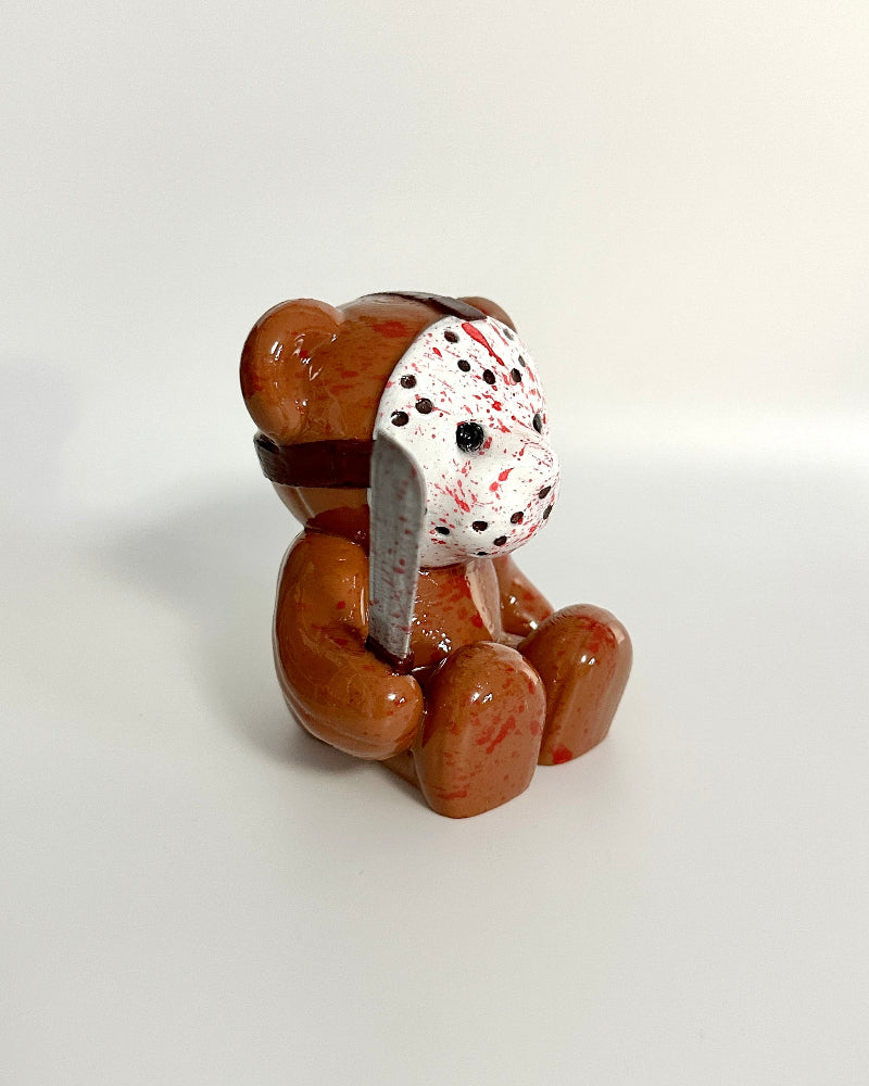 Small brown dog figurine with a polka dot bandage on a white background