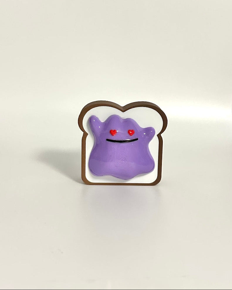 Small purple creature on a piece of bread-shaped toast against a white background