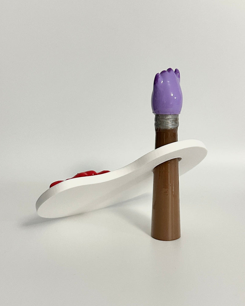 Decorative item with a purple top and white base on a white surface