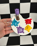 Colorful paint palette with a hand holding it against a checkered background