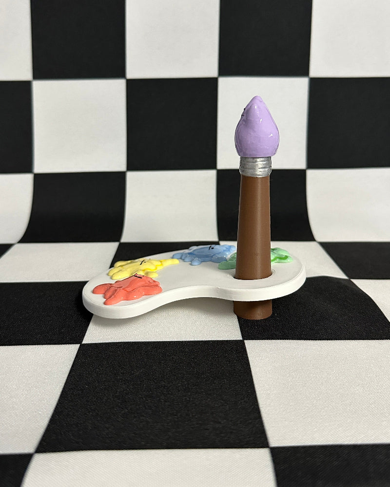 Paintbrush with a purple handle on a color palette against a checkered background