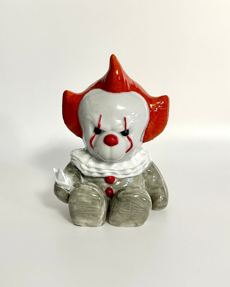 Clown figurine with red hair and white face on a white background