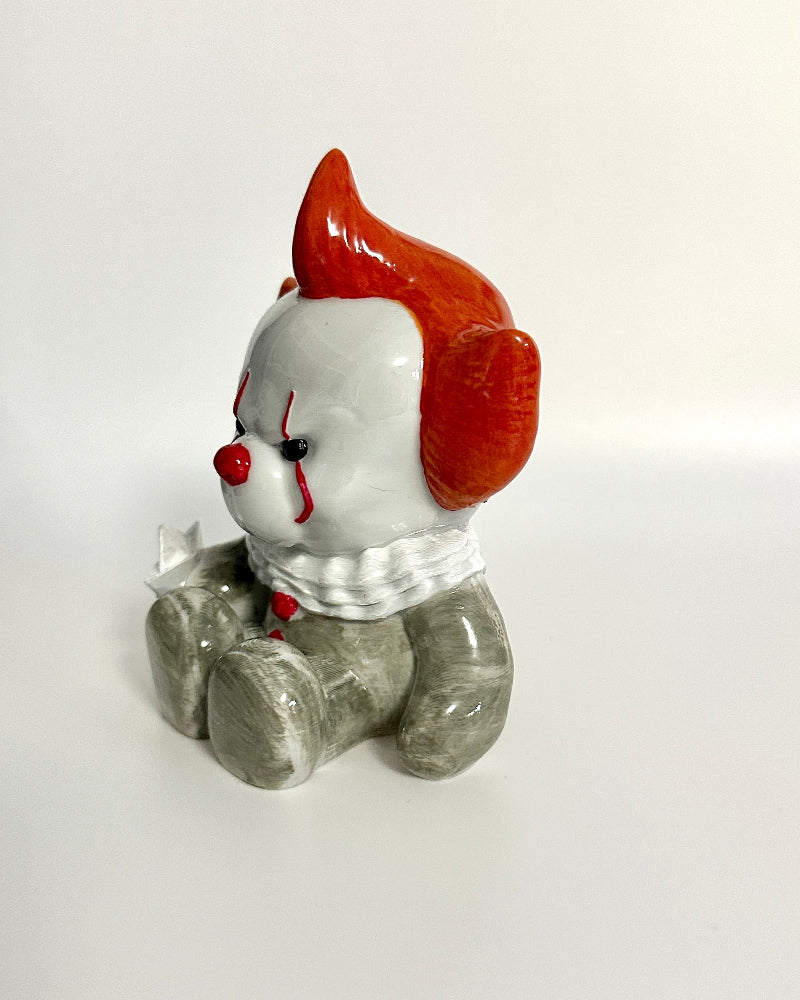 Small figurine of a character with red hair and gray body on a white background