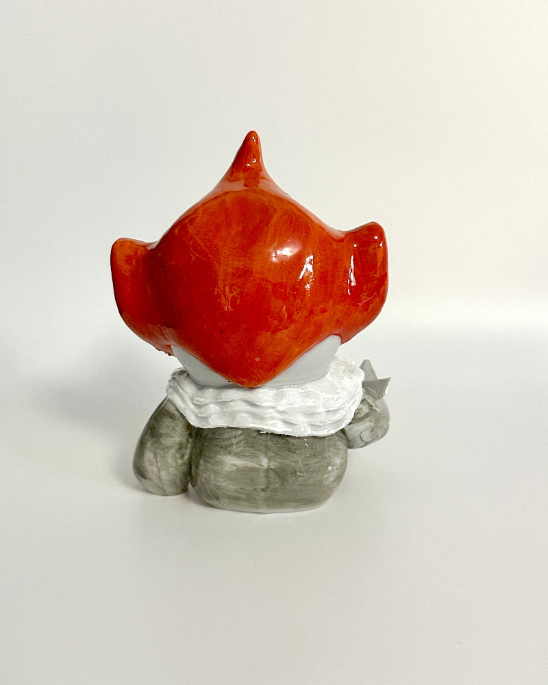 Small figurine with a red head and gray body on a white background