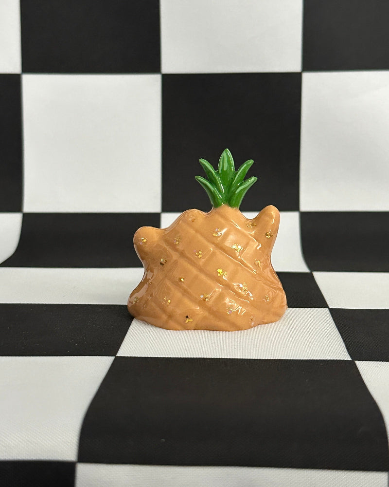 Pineapple-shaped object on a black and white checkered background