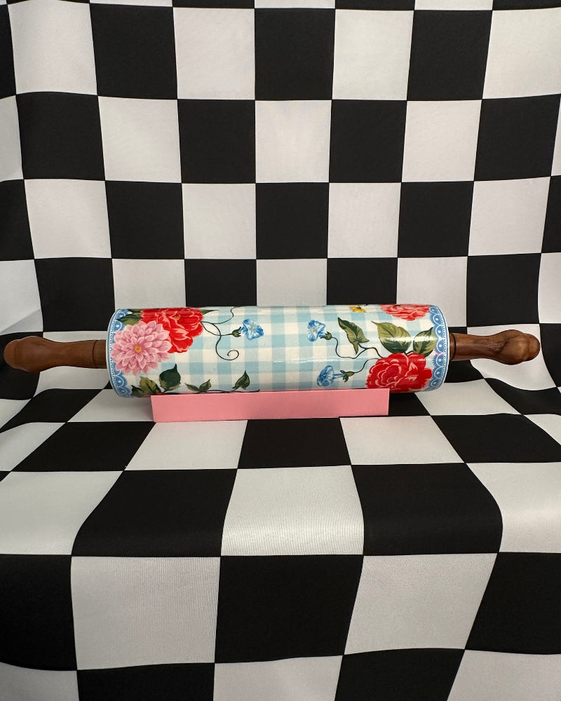 Floral-patterned rolling pin on a checkered tablecloth