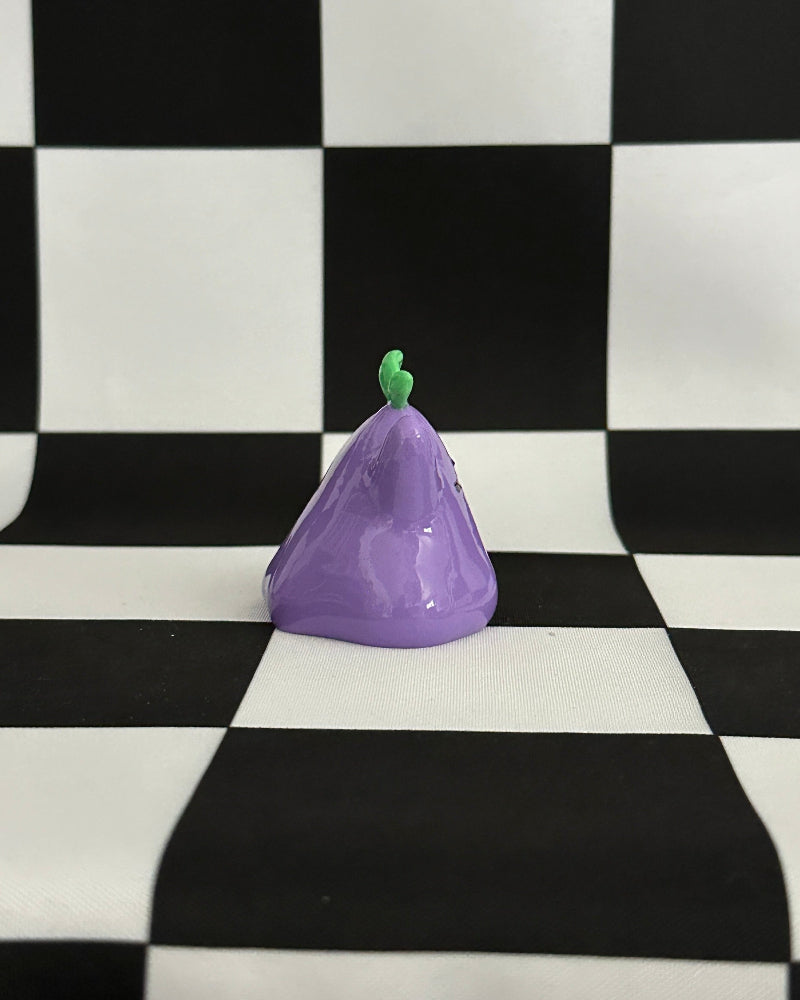 Purple object with a green top on a black and white checkered background