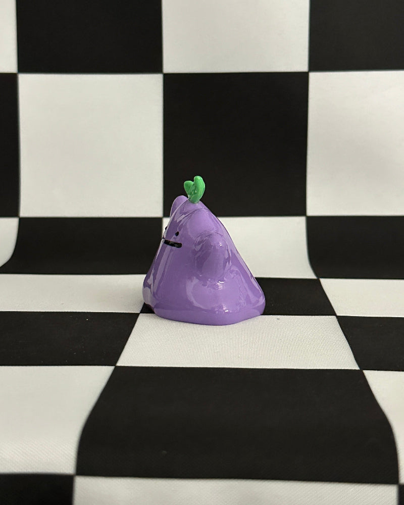 Purple character with a green stem on a checkered black and white background