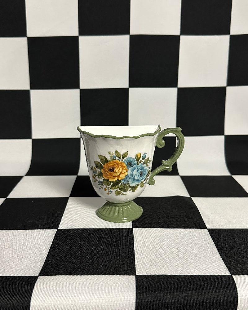 teacup magnet on a black and white checkered background