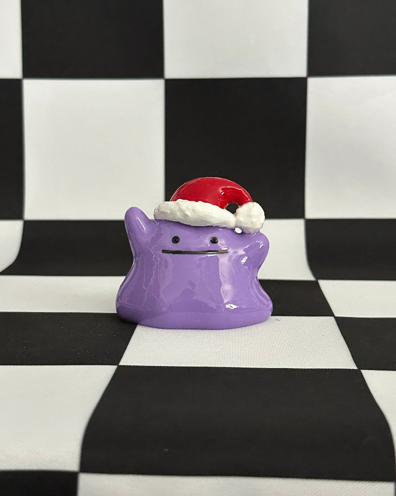 Purple character with a Santa hat on a black and white checkered background