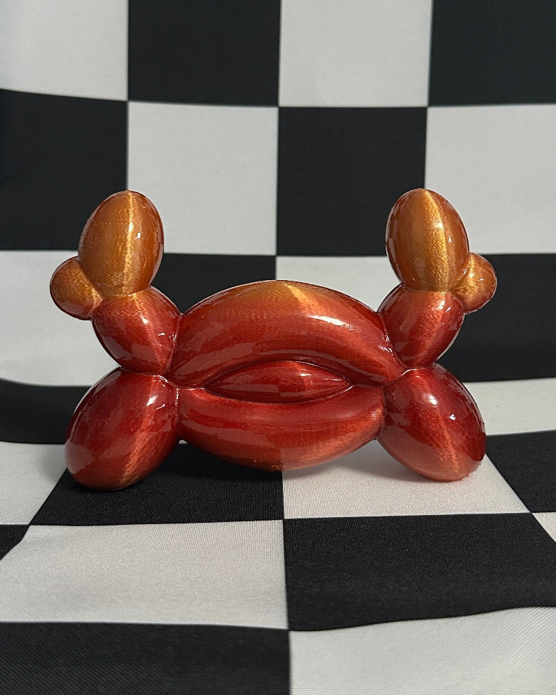 Balloon crab sculpture on a black and white checkered background