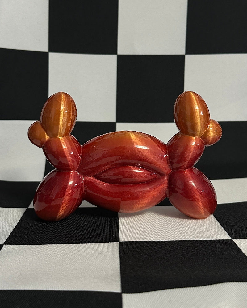 Balloon crab sculpture on a black and white checkered background