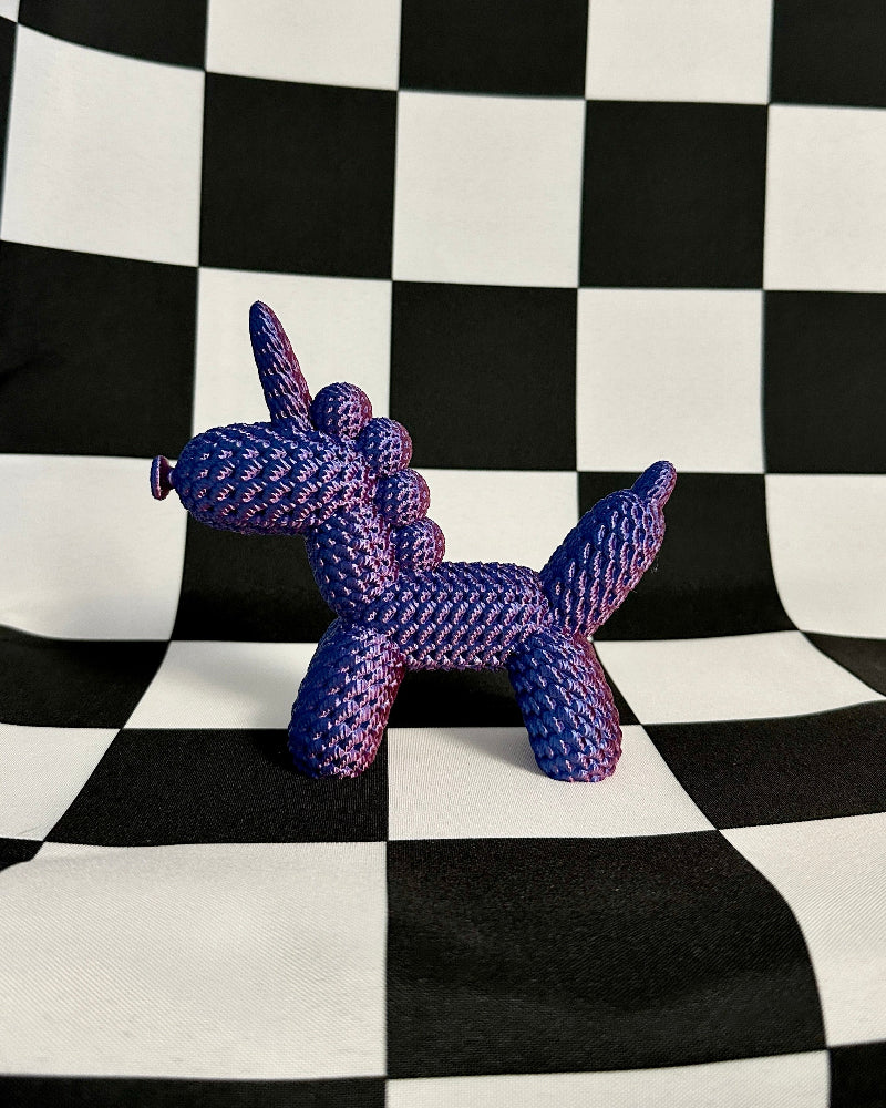 Purple dog-shaped toy on a black and white checkered background