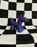 Blue balloon dog sculpture on a black and white checkered background