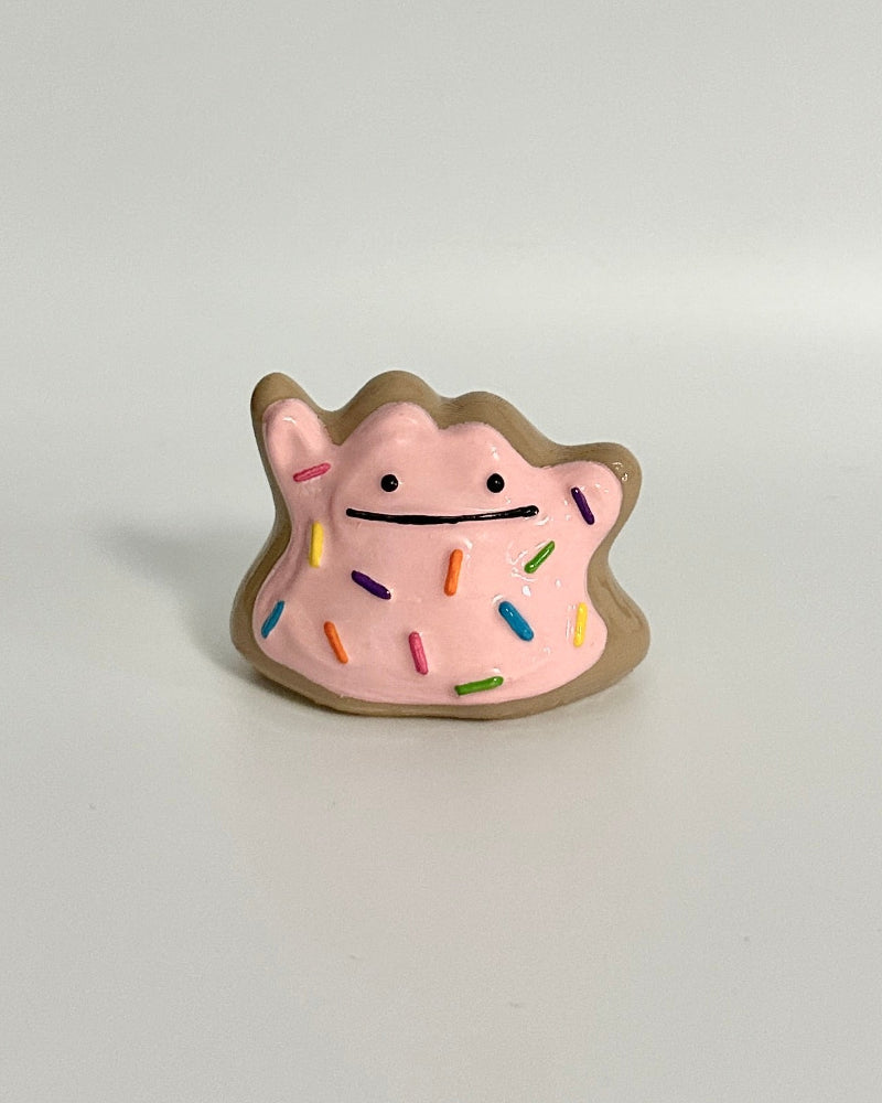 Small pink and gold figurine on a white background