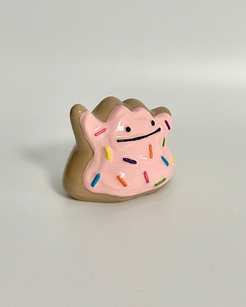 Small decorative item resembling a donut with a face on a white background