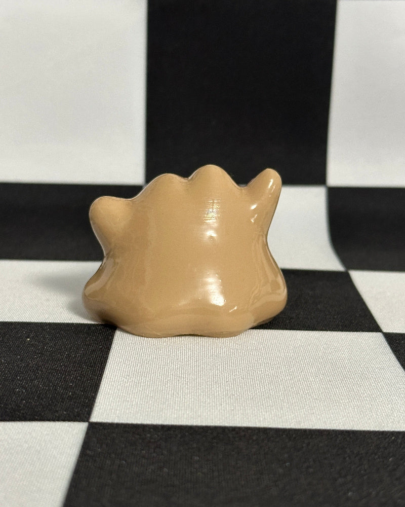 Beige shell-like object on a black and white checkered background