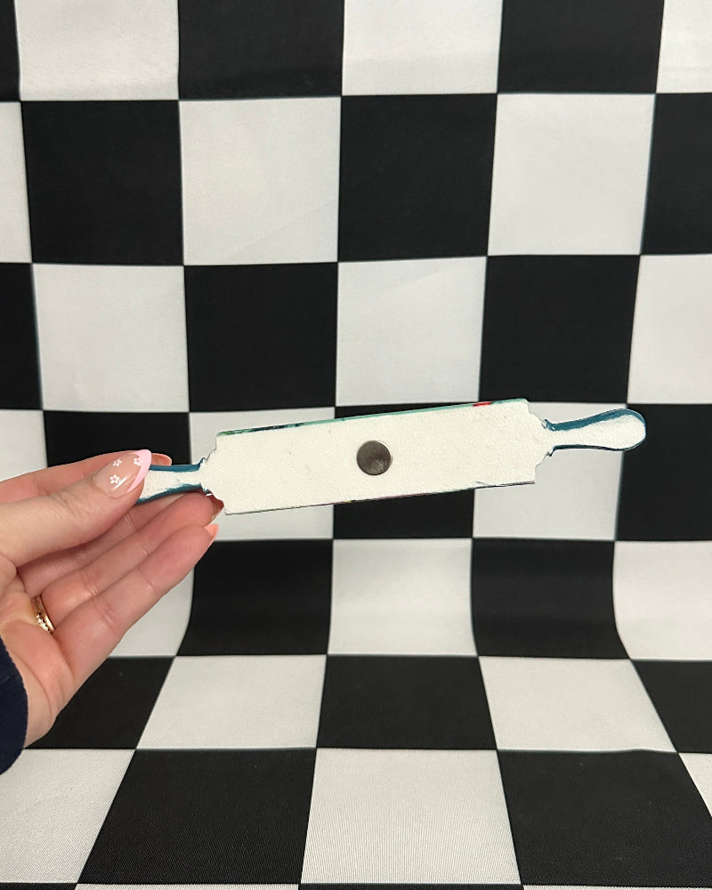 Hand holding a pregnancy test against a black and white checkered background