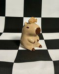 Small figurine of a creature on a black and white checkered background