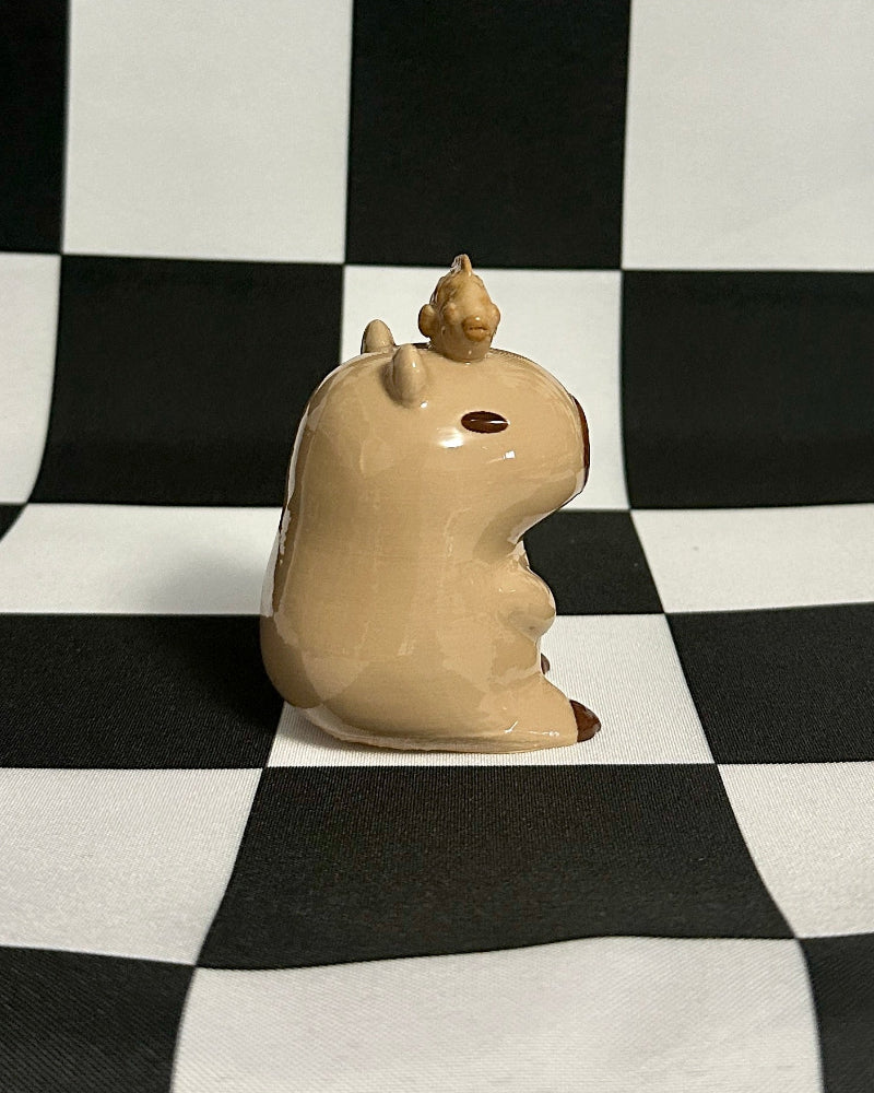 Beige ceramic object on a black and white checkered background