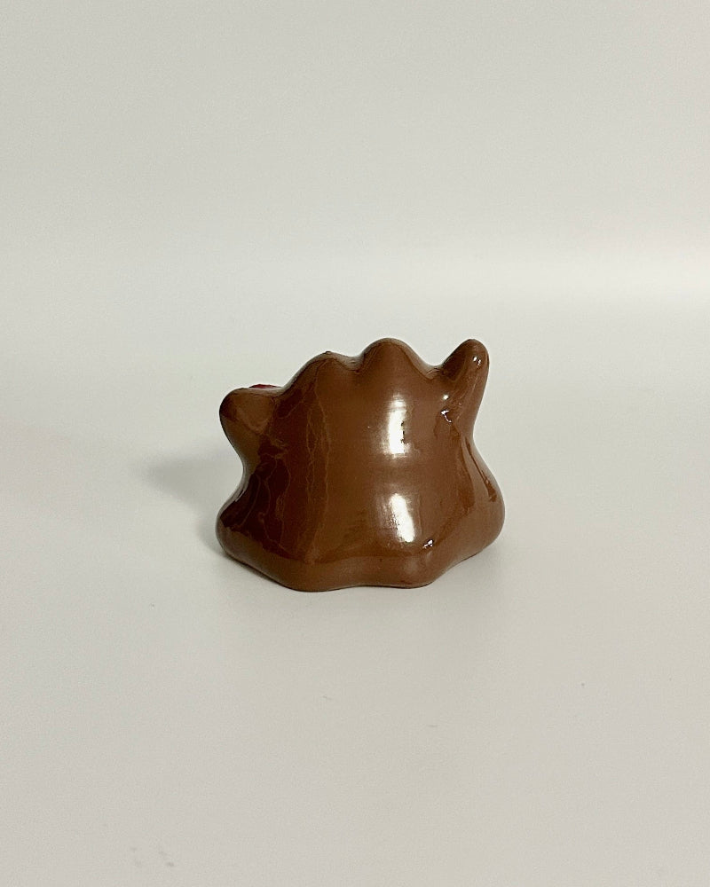 Chocolate bear-shaped candy on a white surface