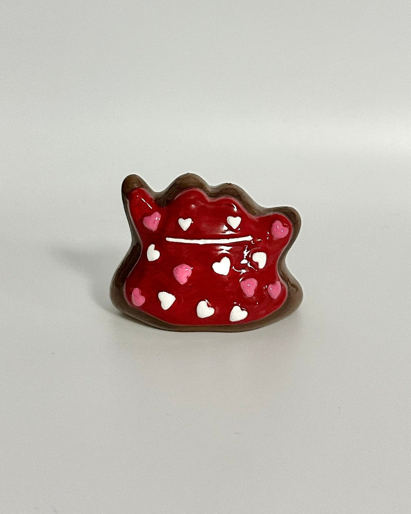 Red decorative object shaped like a cat on a white background