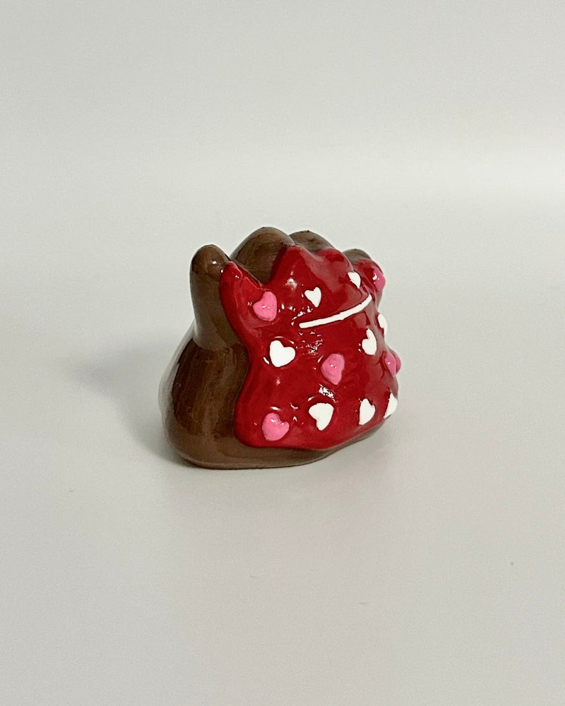 Small figurine of a character wearing a red dress with white polka dots on a white background