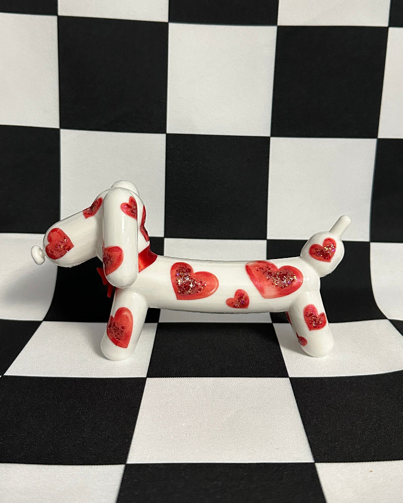 Dog figurine with red heart patterns on a black and white checkered background