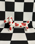 Dog figurine with red heart patterns on a black and white checkered background