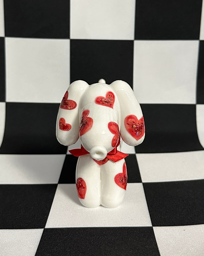 White figurine with red spots on a black and white checkered background