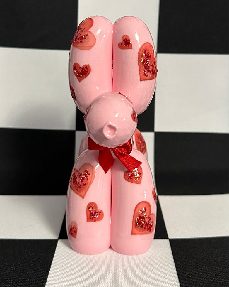 Pink decorative item with heart patterns on a black and white checkered background