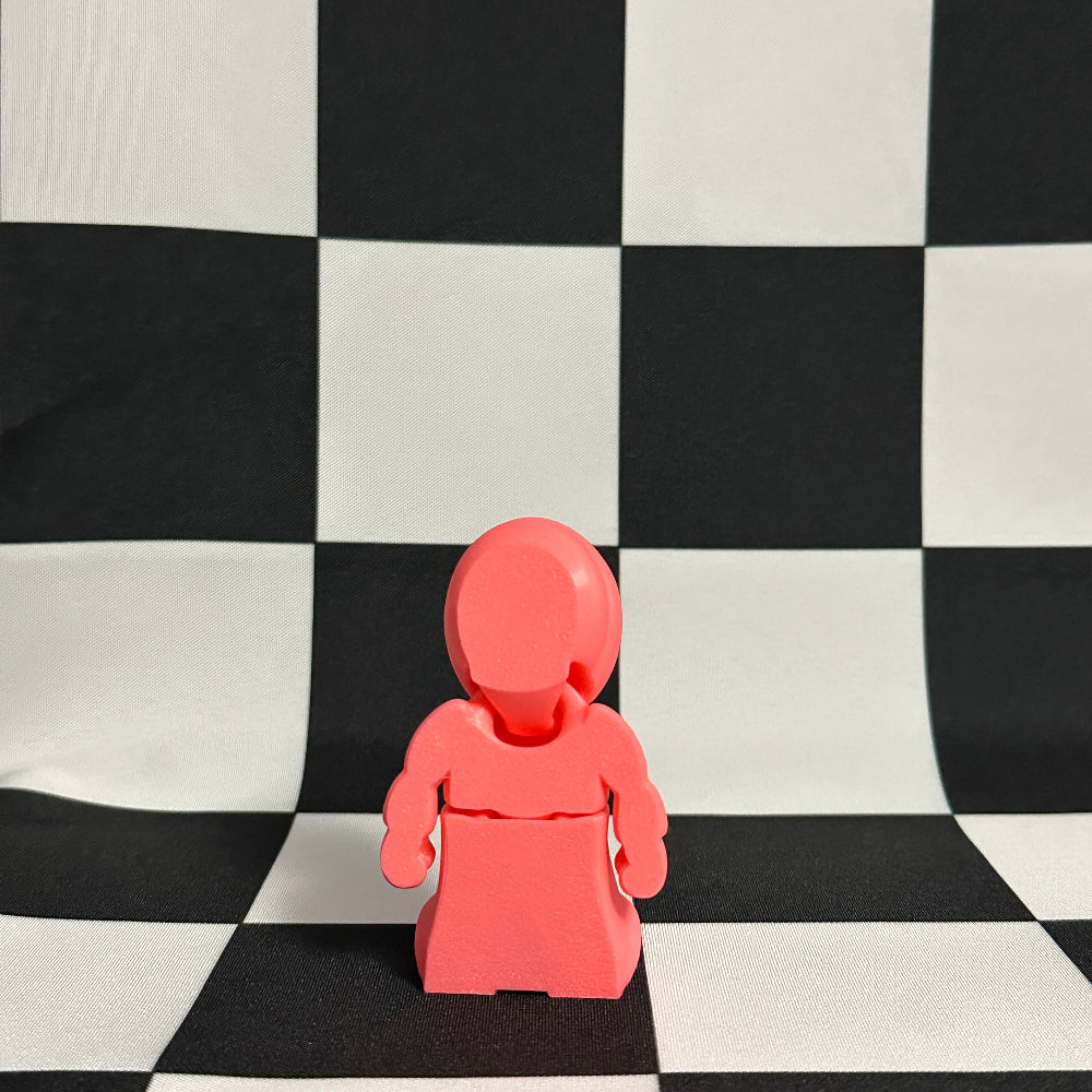 Pink plastic figure on a black and white checkered background