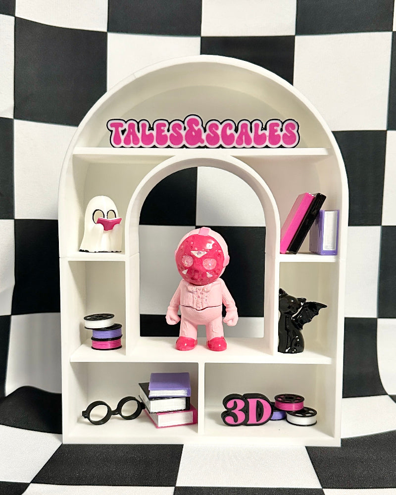 Small white arch-shaped display shelf with various items against a black and white checkered background