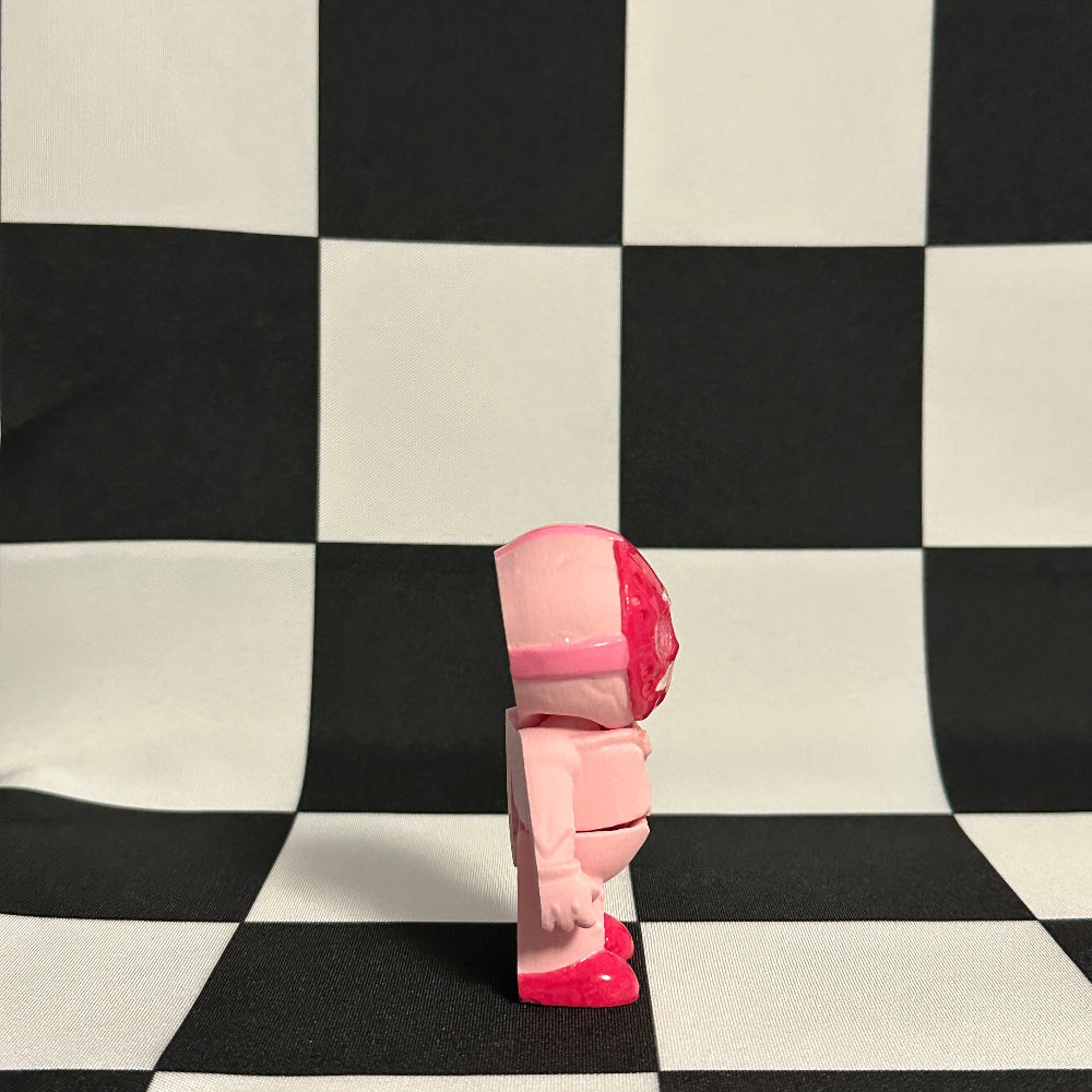 Pink toy figure on a black and white checkered background